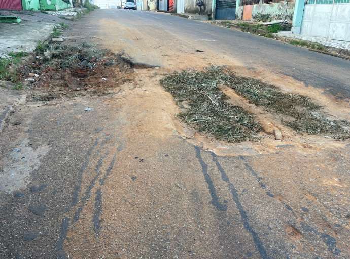 Cansados de esperar pela Prefeitura, moradores da Estação tapam buraco com barro e mato 